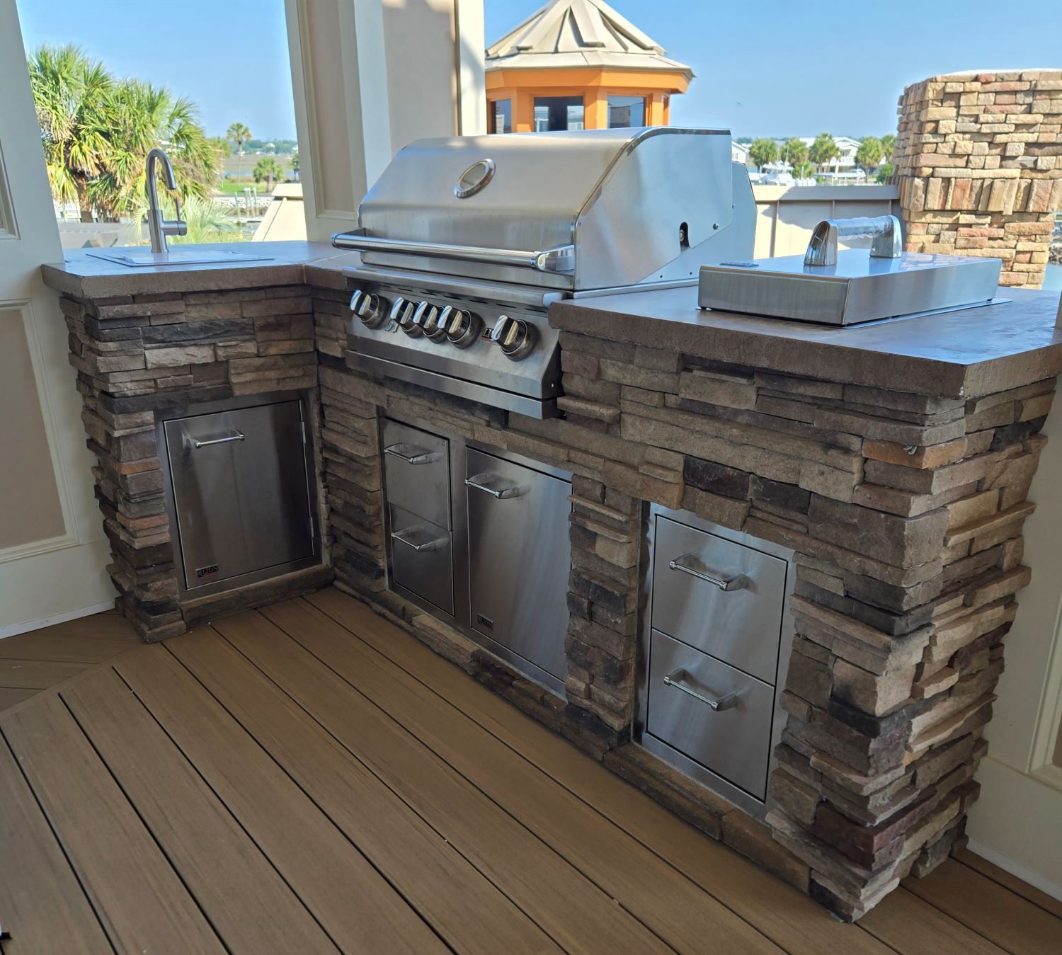 StoneKitchen® outdoor kitchen with grill and sink overlooking the waterway in Garden City, South Carolina