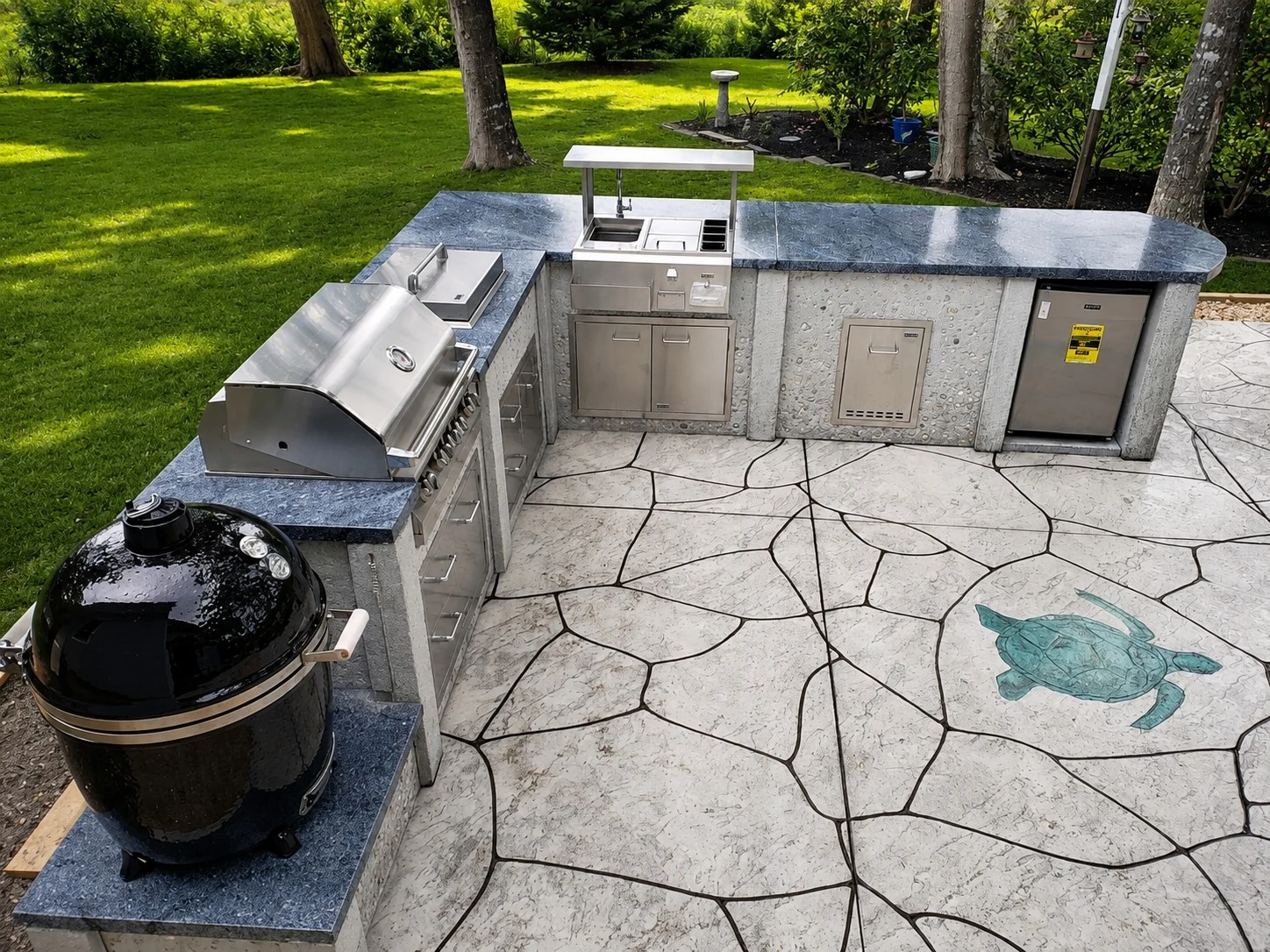 U-shaped StoneKitchen® backyard kitchen with grill, Kamado cooker, sink and refrigeration